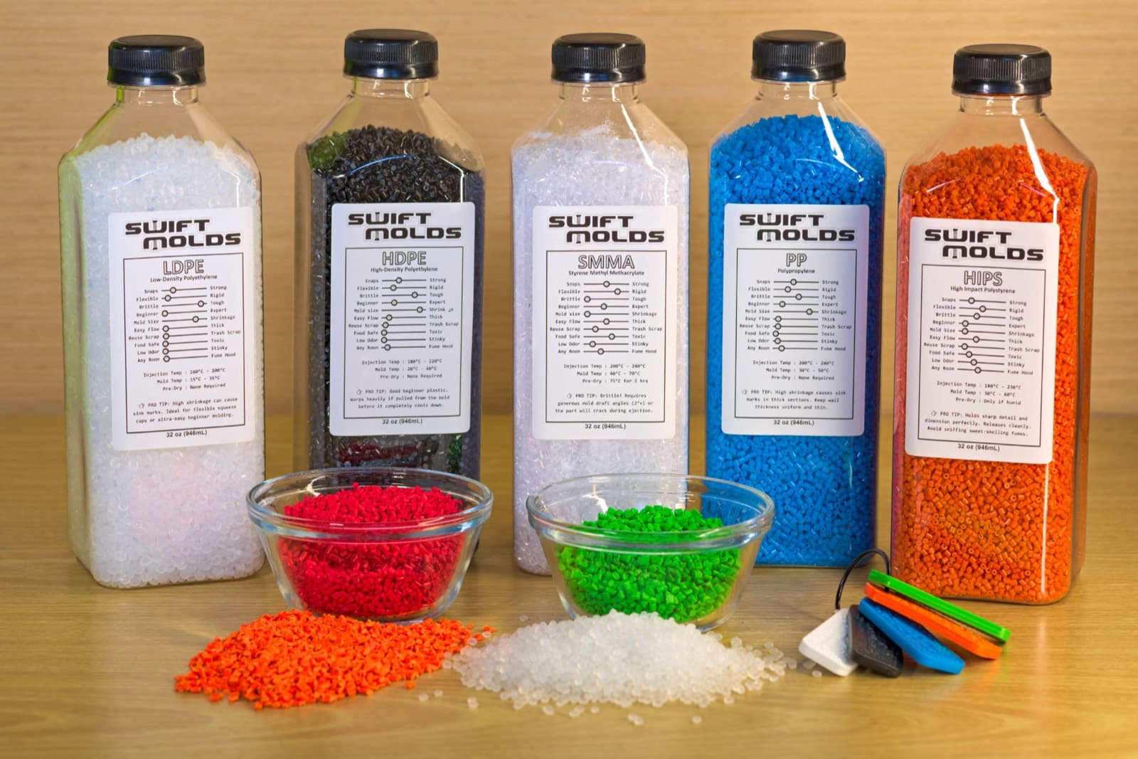 Five bottles of SwiftMolds plastic pellets — LDPE, HDPE, SMMA, PP and HIPS — with loose colored pellets